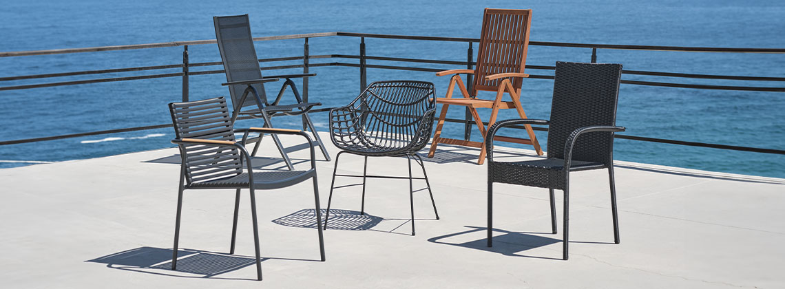 5 sedie da esterno diverse su un terrazzo affacciato sul mare
