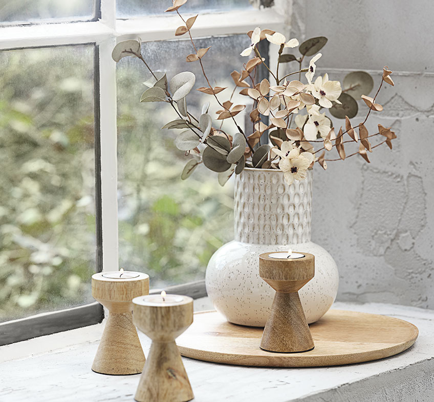 Vaso a rilievo color beige chiaro con fiori artificiali e portacandele in legno
