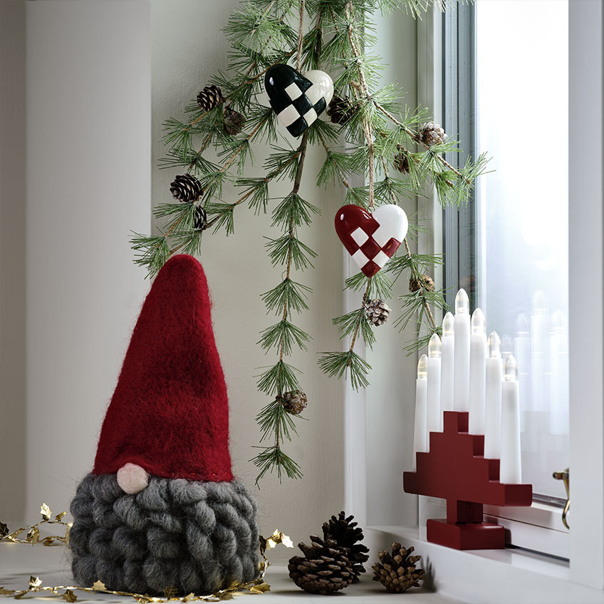 L'elfo di Natale MUGGLESTEN ha una barba lunga e morbida Elfo di Natale scandinavo con barba grigia su un davanzale decorato