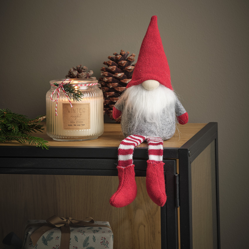 L’elfo di Natale MOLDAVIT e la candela natalizia AMMONIT Elfo di Natale con barba bianca, cappello natalizio e calze