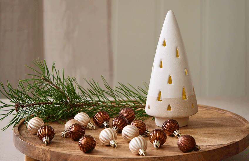 Dettaglio di palline di Natale con decorazione luminosa su vassoio in legno