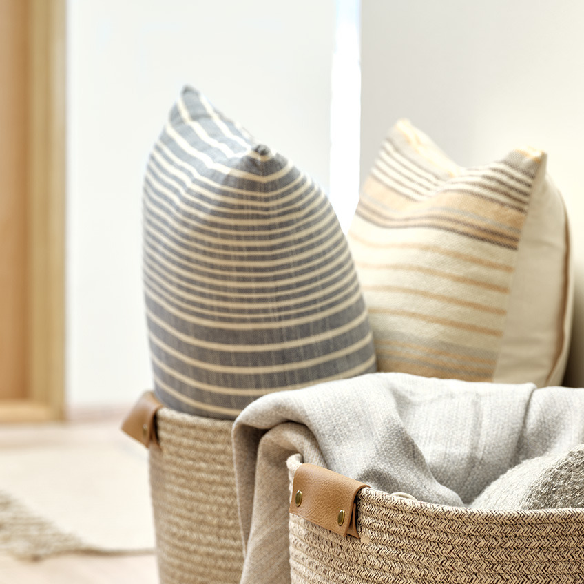 Cuscini decorativi a righe sulle tonalità del grigio e del beige