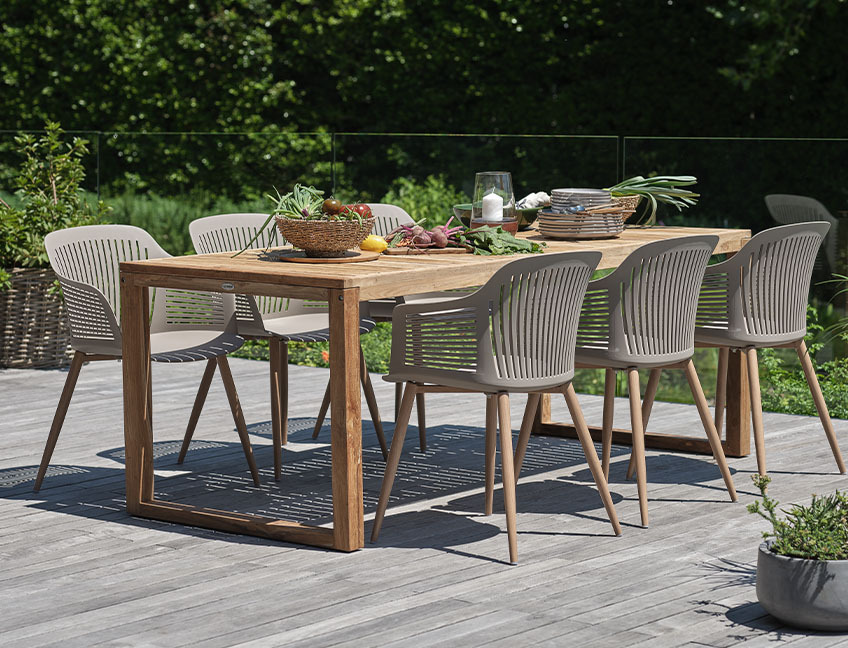 Tavolo da esterno in legno duro e sedie su un patio in giardino