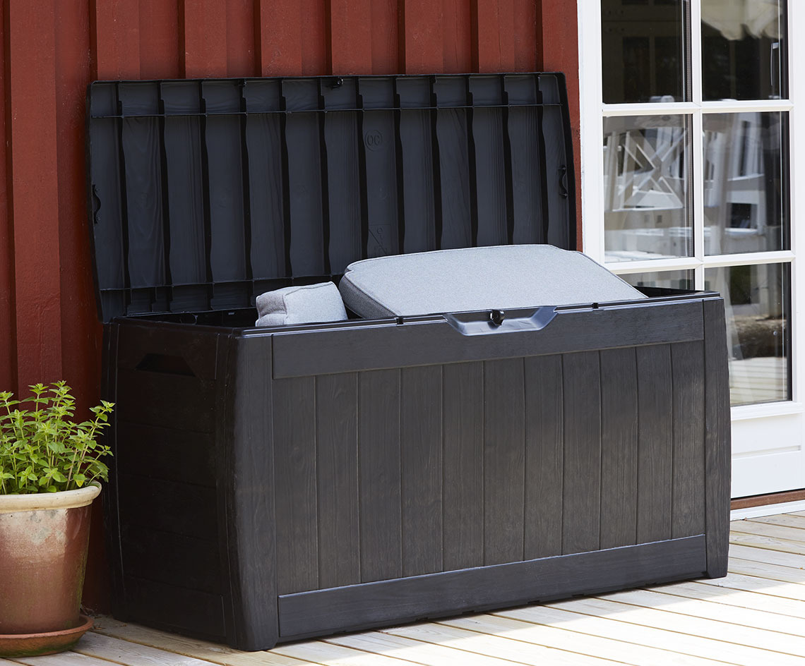Il contenitore per esterno BISNAP pesa solo 6 kg Contenitore per esterno nero con anta aperta su una terrazza