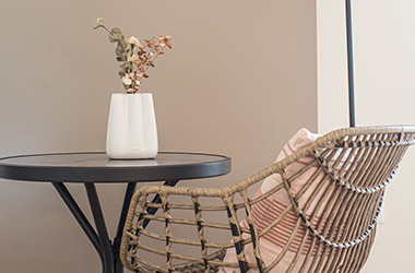 ILDERHUSE garden chair, RADSTRUP bistro table, NATTLILJA cushion and CARLO vase. Closeup of balcony furniture.