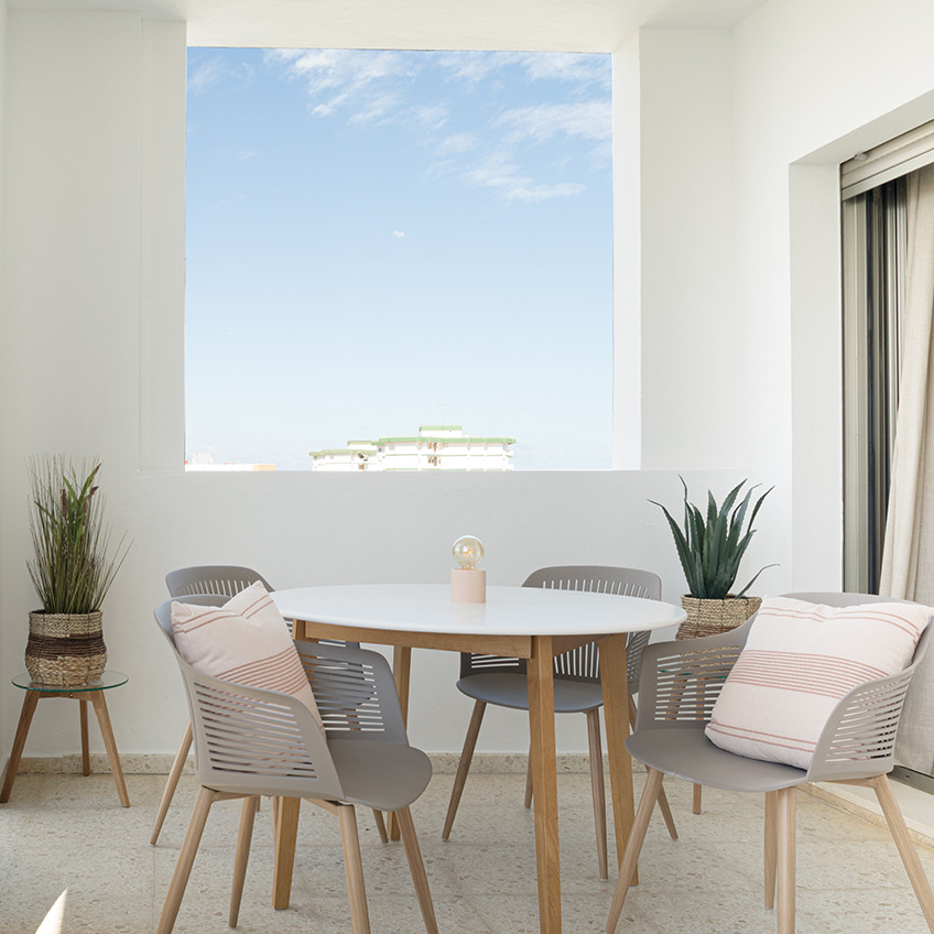 VANTORE garden chair, JEGIND dining table, FALSLED nest og tables, NATTLILJA cushion, ARNOLD battery lamp, CELIUS artificial plant and GODSKE artificial plant. Furnished terrace with table, chairs and decor.
