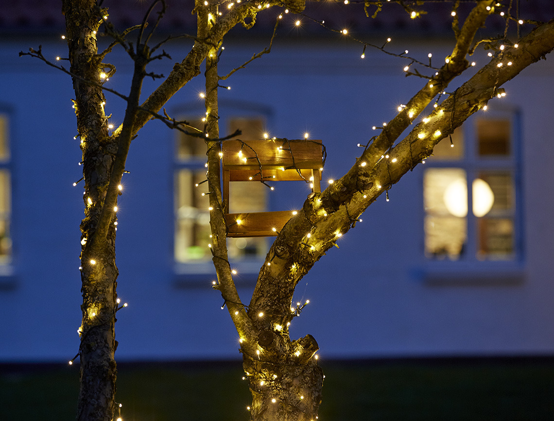 Catena di luci da esterno avvolta interno a un albero