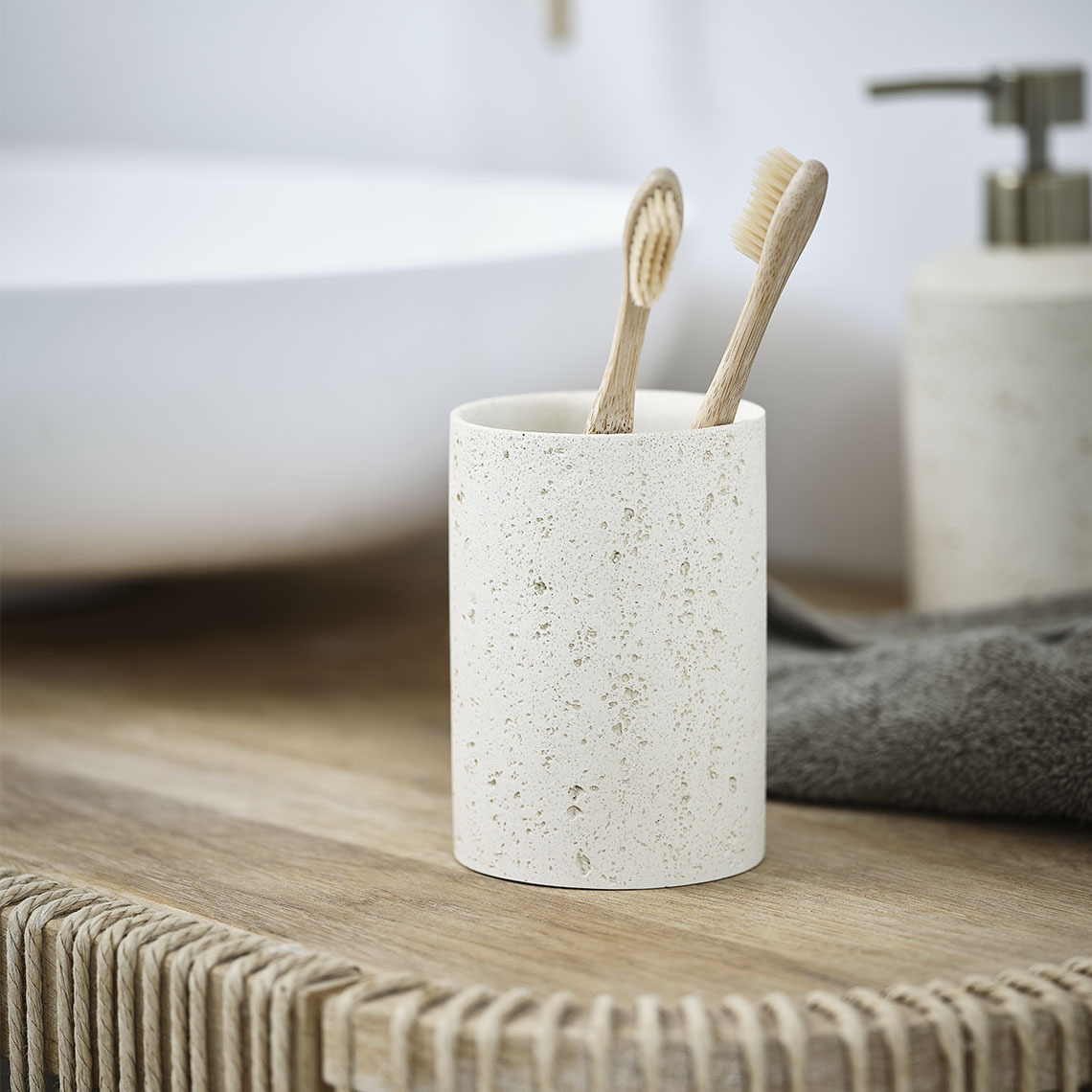 Portaspazzolini in gres beige su un lavandino del bagno