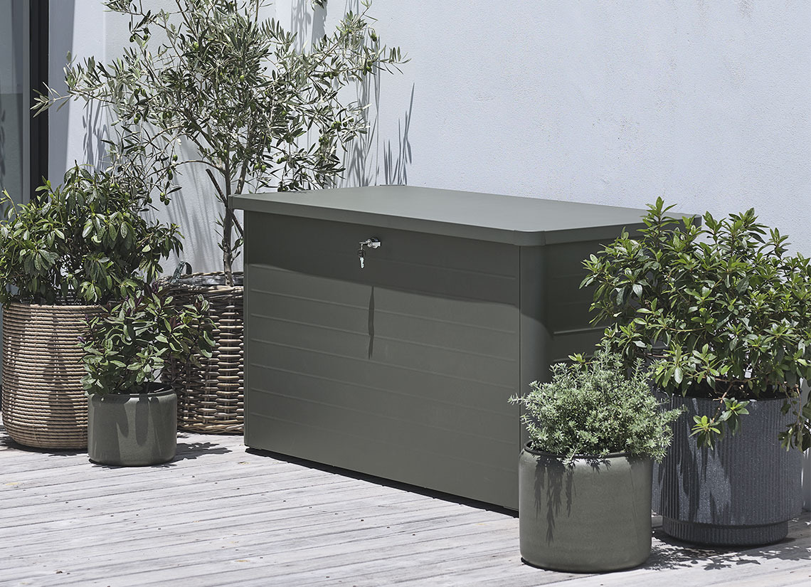 Contenitore per esterni DREJET Contenitore grigio per cuscini su un patio con piante e fioriere
