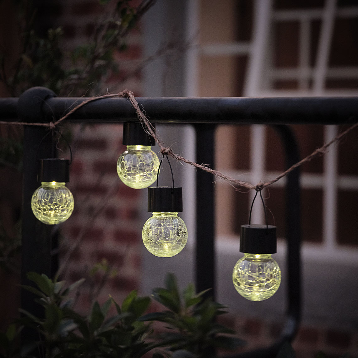 NATTERGAL – luci solari da giardino Piccola lampada solare appesa a una corda lungo una recinzione