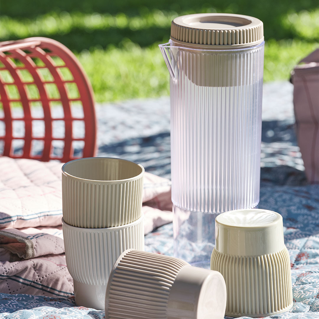 Caraffa TJIM con quattro bicchieri abbinati Accessori da picnic tra cui una caraffa con quattro bicchieri abbinati su una coperta da picnic