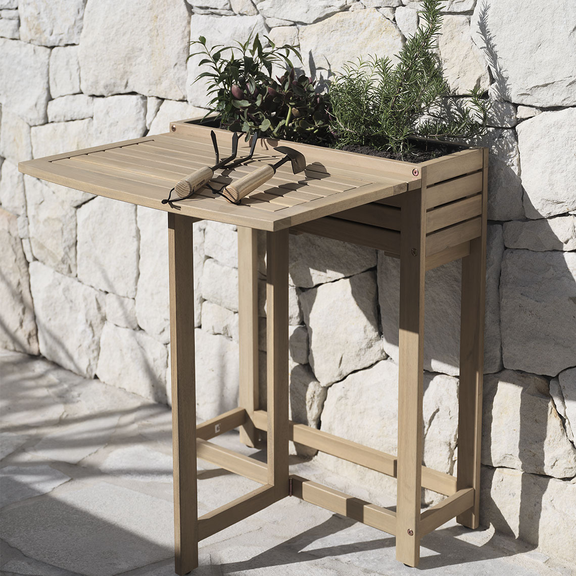 Tavolino pieghevole VANDREFALK Tavolo pieghevole in legno massello con una cassetta per piante integrata, posizionato su un patio