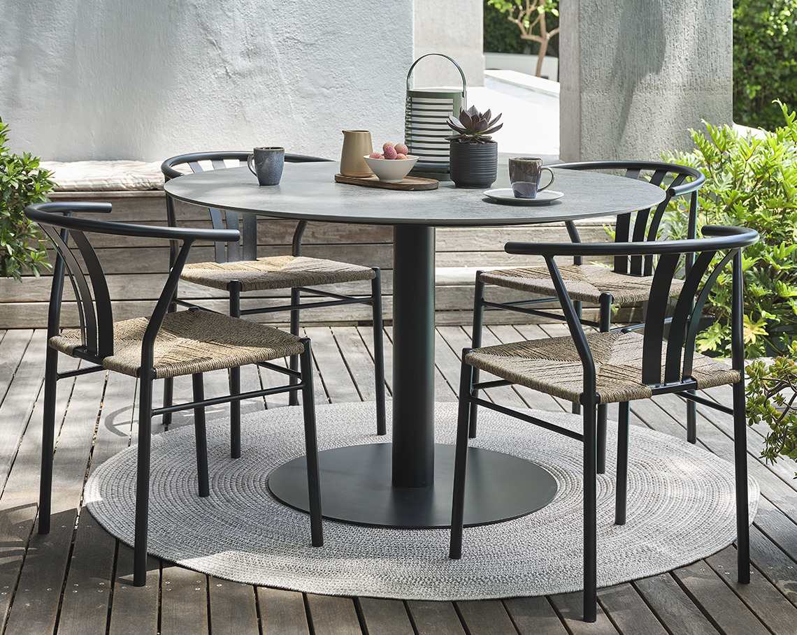 Tavolo da giardino grigio VAMDRUP e sedie TAGMARK Tavolo da giardino con base centrale e quattro sedie su un patio