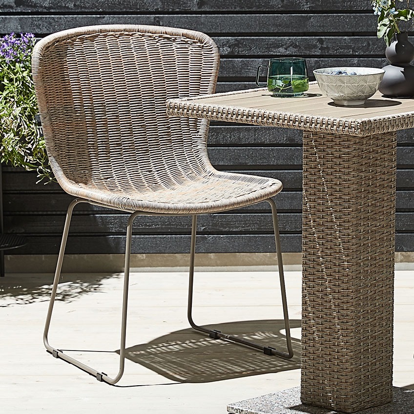Garden chair with a natural look, made of polyrattan and metal with a bistro table made of polyrattan on a patio