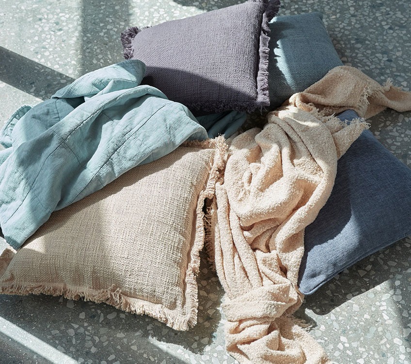 Plaid VALMUE blu, plaid ROSE beige, cuscini HORTENTIA e HORNFIOL Plaid blu, plaid beige e cuscini kaki e blu sul pavimento