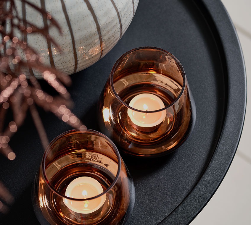 Two tealight holders on a black end table 