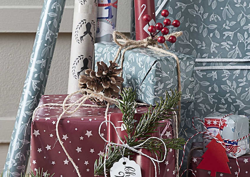 Pacchetti di Natale avvolti con carta regalo e decorati con elementi naturali