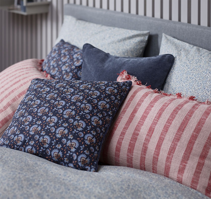 Cuscini decorativi in vari colori sparsi su un letto