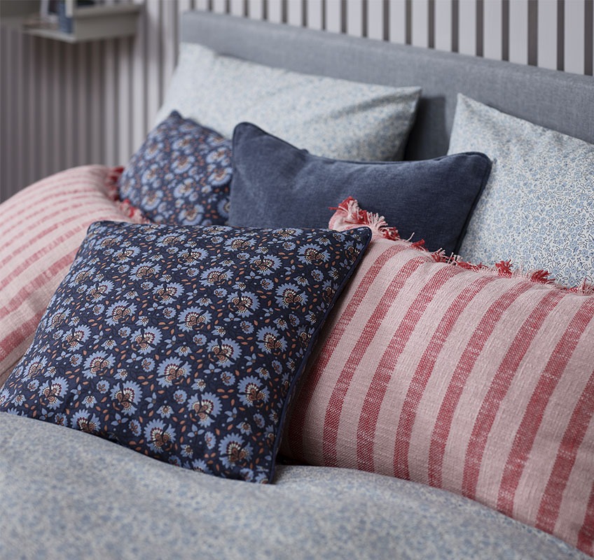 Cuscini decorativi DAGFIOL, KROKUS e HORNFIOL Cuscini decorativi in vari colori sparsi su un letto