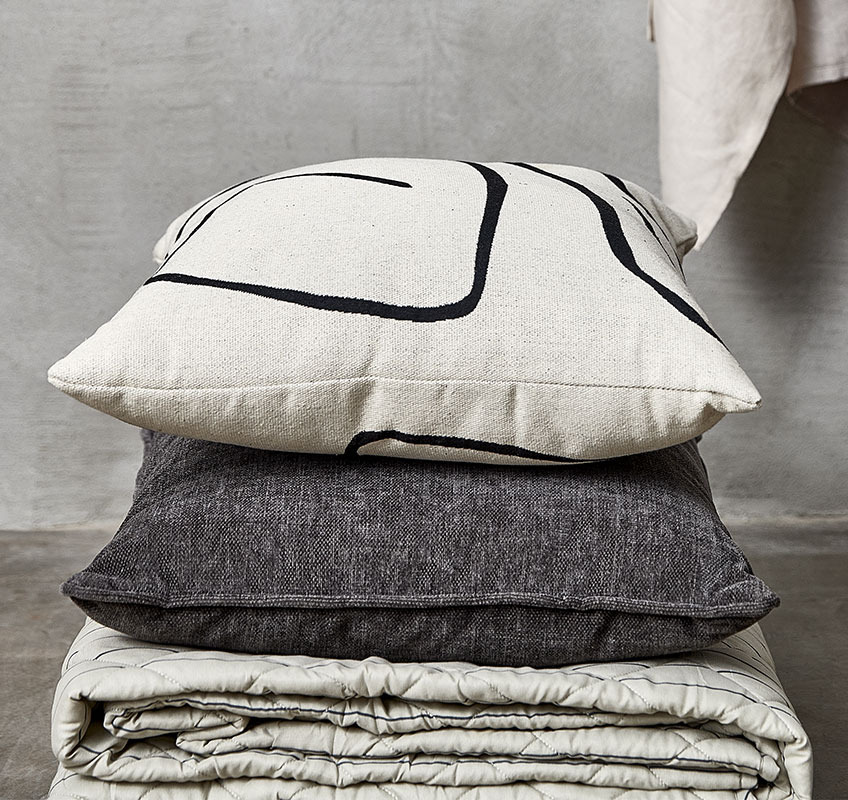 Coperta trapuntata e due cuscini nei colori bianco, beige e grigio