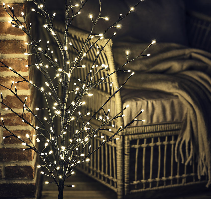 Albero con luci VALE Primo piano di un piccolo albero con luci davanti ad una poltrona da esterno