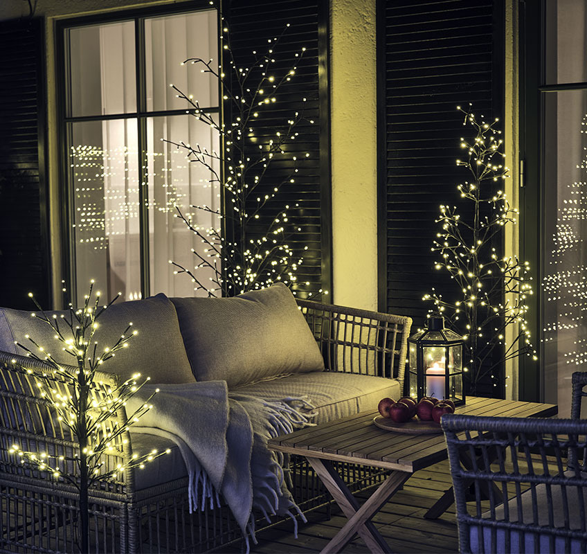 MORGANIT e SKAPOLIT alberi luminosi Alberi di luce all'aperto su un patio in legno con set da salotto