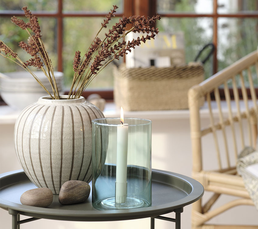 Black end table with vase and candlestick in green glass