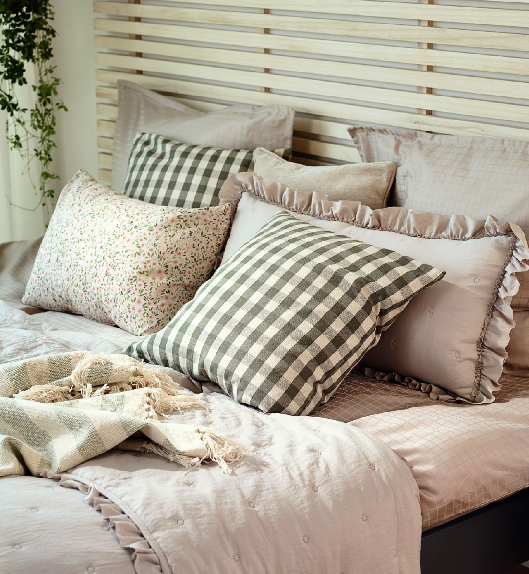 Cuscino con tessuto a scacchi verdi su copriletto a frange color beige