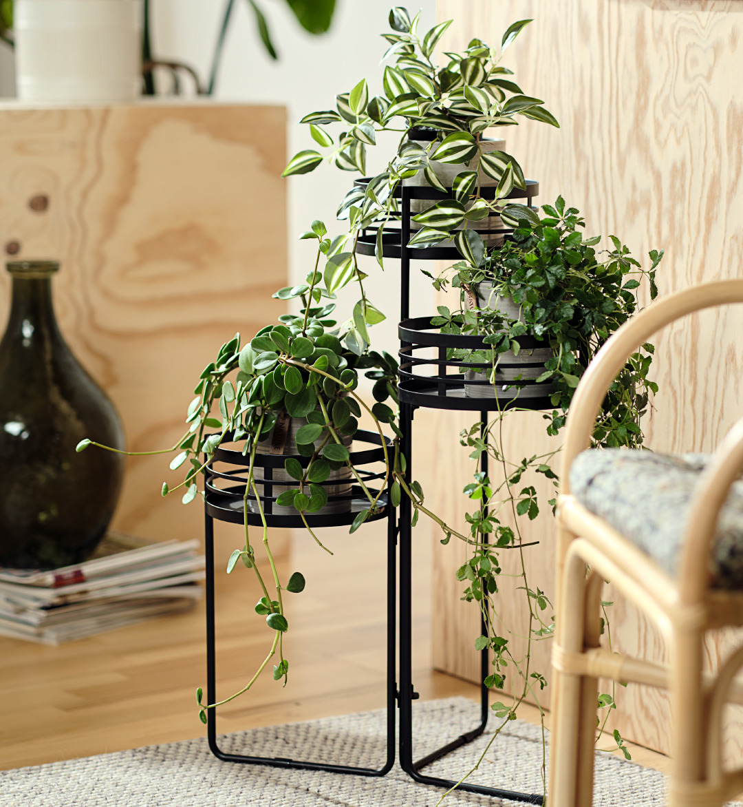 Piantana portafiori in metallo nero con pianta artificiale e vaso decorativo in vetro verde