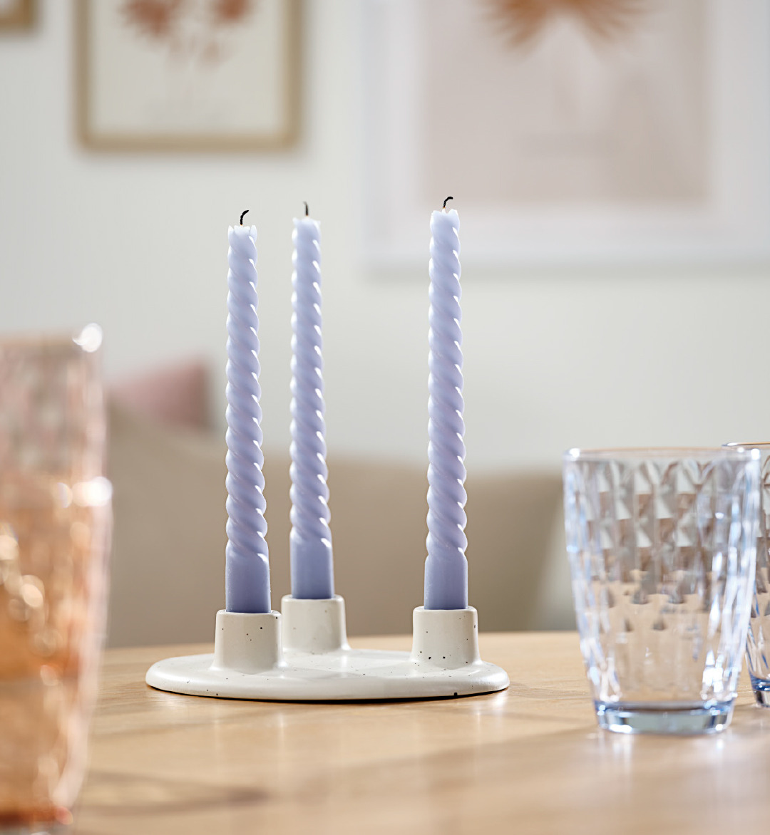 Bicchiere in vetro e portacandela in ceramica con candela blu