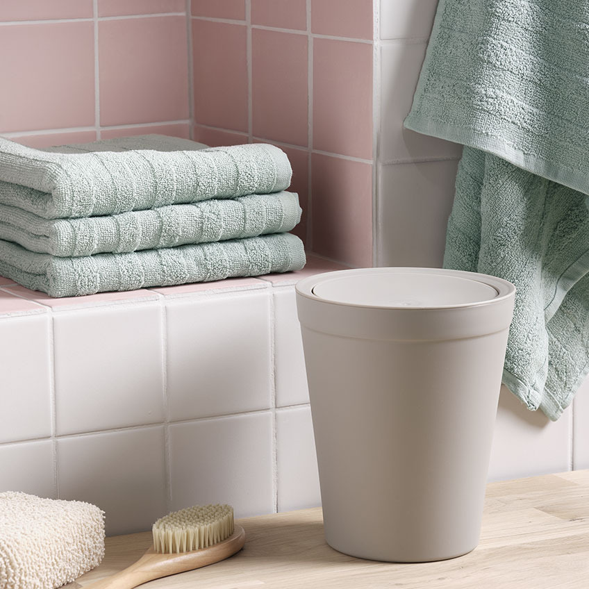 Asciugamani e cestino da bagno in un bagno 